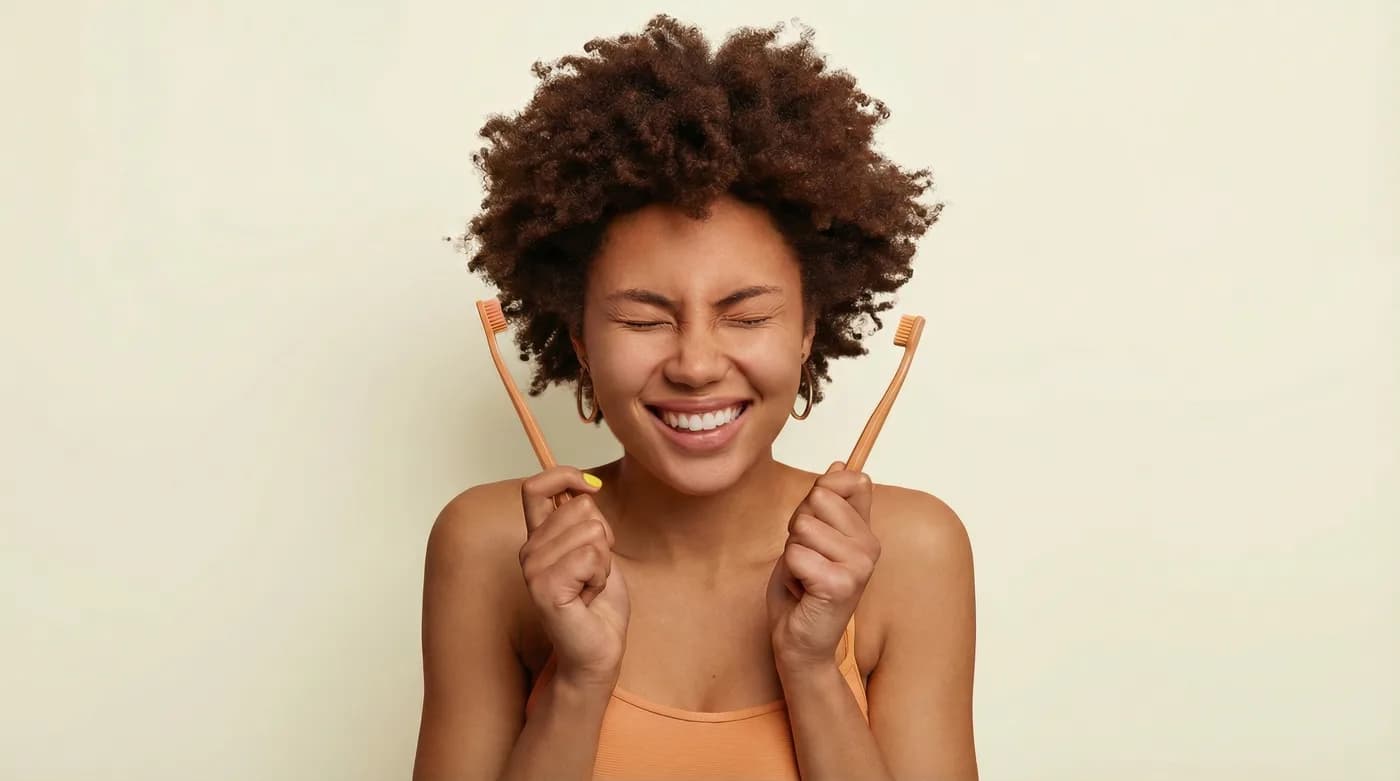 Smiling woman holding two toothbrushes